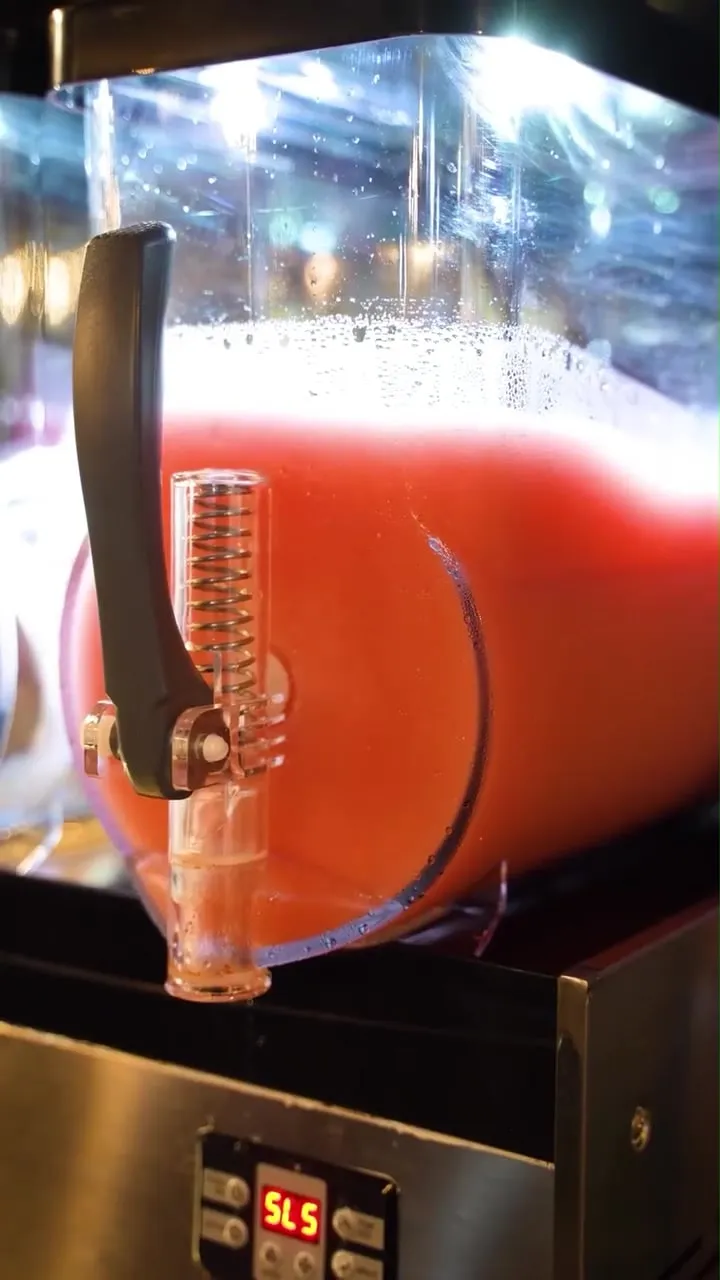 The frozen cocktail machine behind the bar, full and turning
