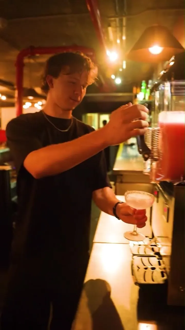 A bartender pouring a frozen cocktail from the slushie machine